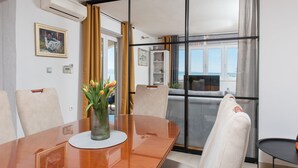 A modern dining area with a wooden table, chairs, and a vase of flowers. - ☆ Luxury apartment ☆ Heated pool ☆ Private parking (split)