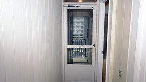 A narrow hallway with a white door leading to a balcony. - One-bedroom and one and a half bath condo on ocean block! (Ocean City)