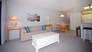 A cozy living room with a sofa, coffee table, and dining area. - One-bedroom and one and a half bath condo on ocean block! (Ocean City)
