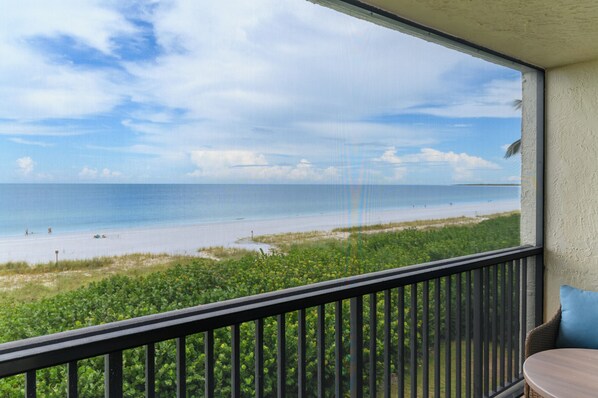 Ein Balkon mit Blick auf einen Strand und das Meer.