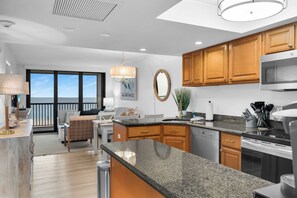 A modern kitchen with wooden cabinets, a stainless steel range, and a large island. - 2 Bed South End Beachfront Condo at Popular Seawinds (Marco Island)