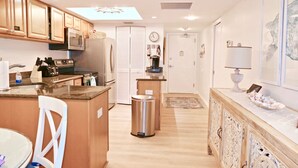 Una cocina moderna con armarios de madera, electrodomésticos de acero inoxidable y una isla central.