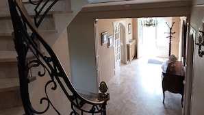 A grand staircase with ornate black metal railings and a marble floor.
