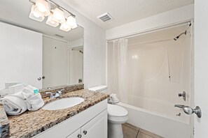 Une salle de bain avec un lavabo, des toilettes et une douche.