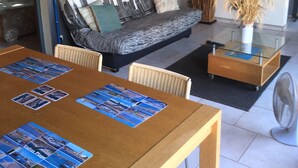 Un salon moderne avec un canapé, une table à manger et une plante décorative.
