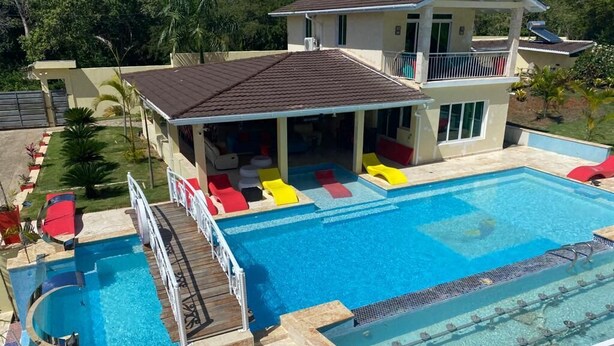 A two-story house with a swimming pool, outdoor seating, and a covered patio area. - Family Friendly~Chef Service- Book 8 to 14 Rooms (Sosua)