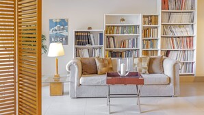Un salon comprenant un canapé, une table basse et deux bibliothèques remplies de livres.
