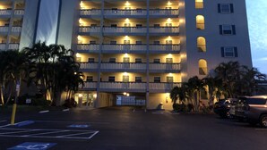 A multi-story hotel with a central entrance, multiple balconies, and a parking area with handicapped parking spaces. -  Updated and Restored Beachfront Condo with Spectacular Views of the Gulf (Redington Shores)