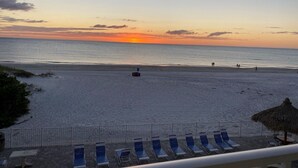 A beach view with lounge chairs and a thatched umbrella. -  Updated and Restored Beachfront Condo with Spectacular Views of the Gulf (Redington Shores)