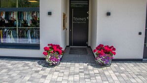A storefront with a sign reading "TEVIN'S BOUTIQUE SUITES" and a window displaying clothing items. - Tevini Boutique Suites - Apartment Fire, balcony (Zell am See)