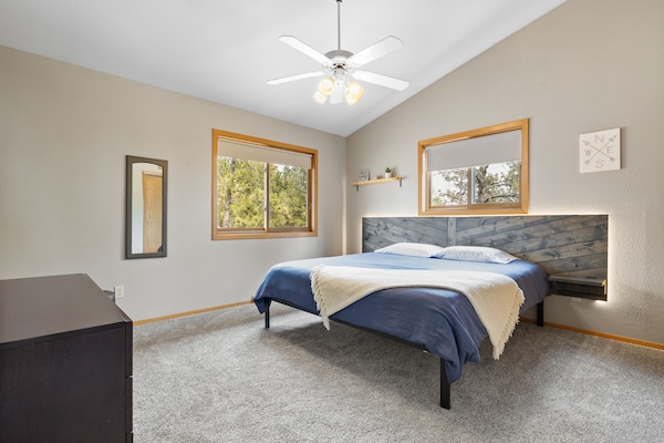 Main bedroom, king size bed w/ backlit headboard, dresser, and closet space.