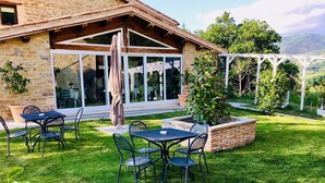 A stone building with a patio area featuring outdoor seating and a pergola. - Fonte Rosa farmhouse with pool (Fiastra)