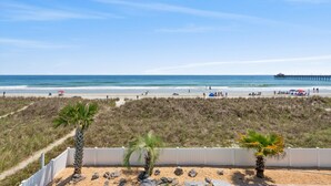 A beach with a white fence, palm trees, and a pier in the background. - 2 Night Minimum Stay in Off Season - Pet Friendly 8BR Oceanfront Home in Cherry Grove, Game Room & Beautiful Pool (ISLELAG) (North Myrtle Beach)