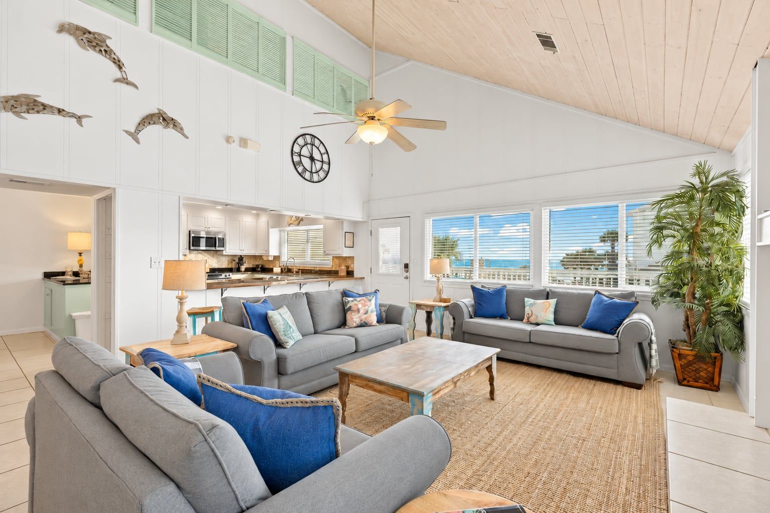 A spacious living area with a modern kitchen, a ceiling fan, and a large window providing a view of the outdoors.