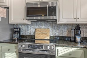 A kitchen with stainless steel appliances, including a microwave, coffee maker, and stove.