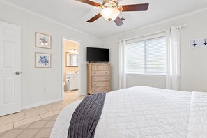 A bedroom with a bed, a ceiling fan, a dresser, a television, and a window with blinds. - Waterside Wave - 5BR/3BA Gulf Trace Home - Sleeps 14 - Private Pool & EV Charger (Santa Rosa Beach)