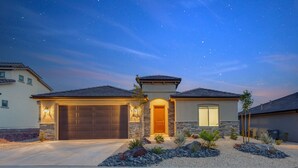 A two-story house with a stone facade, a dark brown garage door, and a well-lit front entrance. - Paseos 1146| Private Hot Tub, Pickleball Court, Access to Community Pool (Washington)