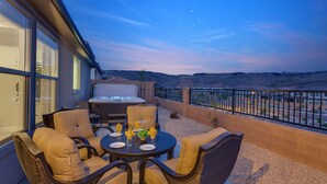An outdoor patio with wicker furniture, a hot tub, and a scenic view of the desert. - Paseos 1146| Private Hot Tub, Pickleball Court, Access to Community Pool (Washington)