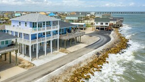 A coastal property with multiple buildings, a pier, and a view of the ocean.