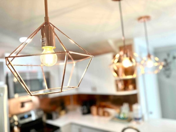 A modern kitchen with pendant lights and a central island.