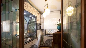A compact kitchen with a marble countertop, a built-in oven, and a window with a decorative grille. - It is time to dream enjoying the steam  bath  listening lovely music  (Roma)