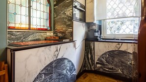 A kitchen with marble countertops, a built-in oven, and a window with stained glass. - It is time to dream enjoying the steam  bath  listening lovely music  (Roma)