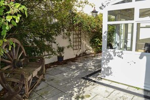 A white building with large windows and a wooden cart outside.