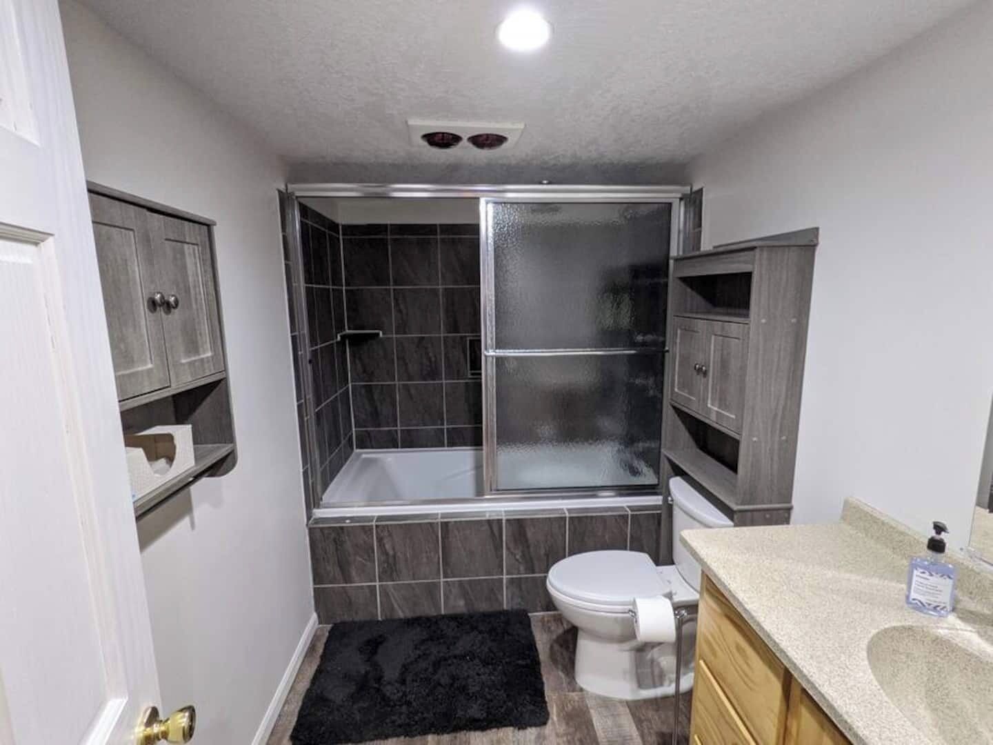 A bathroom with a shower, toilet, and vanity.