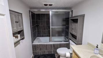 A bathroom with a shower, toilet, and vanity.