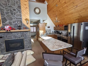 Enjoy cooking in this well-equipped kitchen with a fireplace, island, and bar stools.