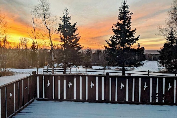 Sunset view from balcony with lake superior between the trees.