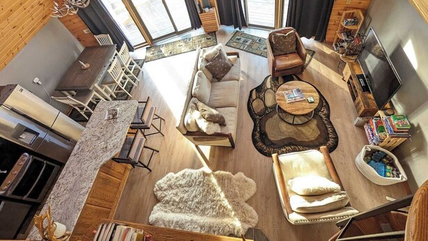 Un acogedor interior de cabaña con sofá, sillón y televisor.