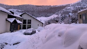 Ein schneebedecktes Dorf mit Häusern und einem geparkten Auto.
