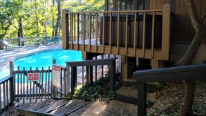 A wooden deck with a pool, surrounded by trees and a 'Keep Gate Closed' sign. - Pool Side Getaway With Hot Tub at Tan-Tar-A Estates! Bordering Margaritaville! (Osage Beach)