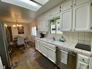 Enjoy cooking in this well-equipped kitchen with a stainless steel refrigerator, oven, and sink.