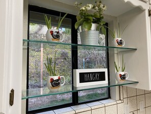 Decorative items on display, featuring ceramic mugs and a potted plant.