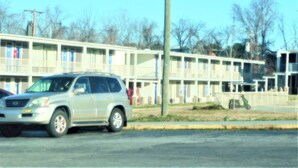 A motel with multiple rooms, a parking lot, and a building with a flat roof. - Park View Inn (Greensboro)