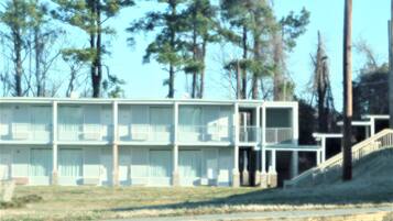 A motel with multiple floors, balconies, and a staircase leading to the entrance.