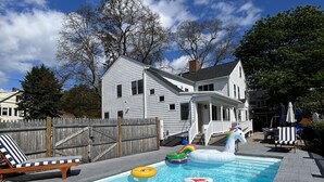 A swimming pool with inflatable toys and lounge chairs.