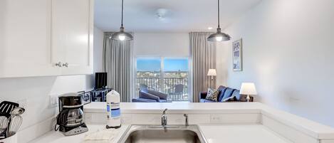 A modern kitchen with a stainless steel sink, a coffee maker, and a Keurig coffee pod.