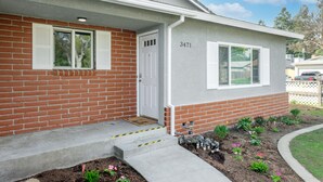 A two-story house with a brick facade, a white door, and a number '3471' on the side. - Hidden Gem Upgraded 4/2 in NW Fresno w RV Parking (Fresno)