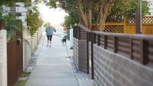 A narrow sidewalk with a wooden fence on one side and a metal fence on the other. - Luxury, Ground Floor Studio #4 just 167 steps to the Best Beach in San Diego! (San Diego)