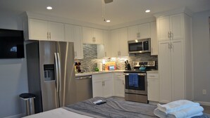 A modern kitchen with stainless steel appliances, white cabinetry, and a built-in microwave. - Luxury, Ground Floor Studio #4 just 167 steps to the Best Beach in San Diego! (San Diego)