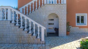 A two-story building with a stone staircase and white balustrades leading to an arched entrance. - Apartment Laura by Interhome (Pula/Galižana)