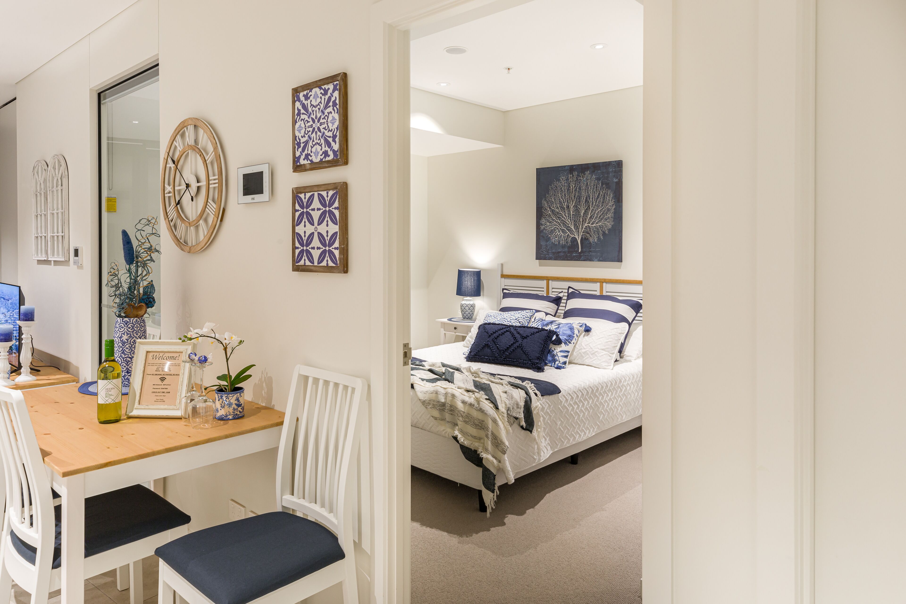 A bedroom with a bed, bedside table, lamp, and wall art.