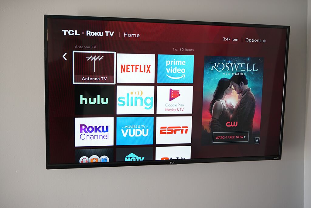 A TCL Roku TV displaying various streaming services and a movie poster.
