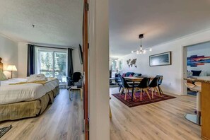 Une chambre d’hôtel comprenant un lit, un bureau et un coin repas avec des chaises et une table.