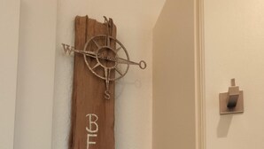 A wooden sign with "BEACH" and "500" on a wall, a door handle, and a light switch. - App. Sylter Traumzeit (Sylt)
