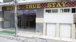 A hotel named "HOTEL TRUE STAY" with a sign above the entrance.