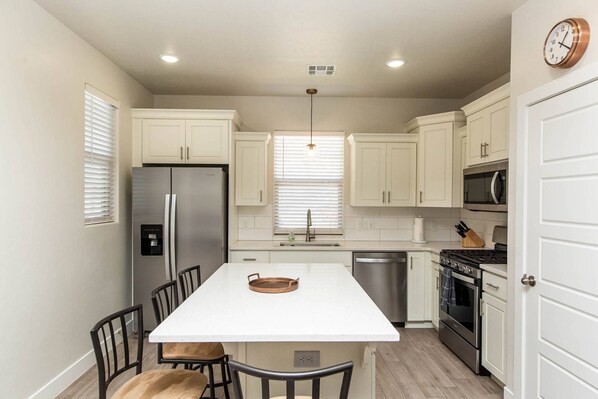 Enjoy cooking in this well-equipped kitchen with a central island, stainless steel appliances, and ample cabinetry.